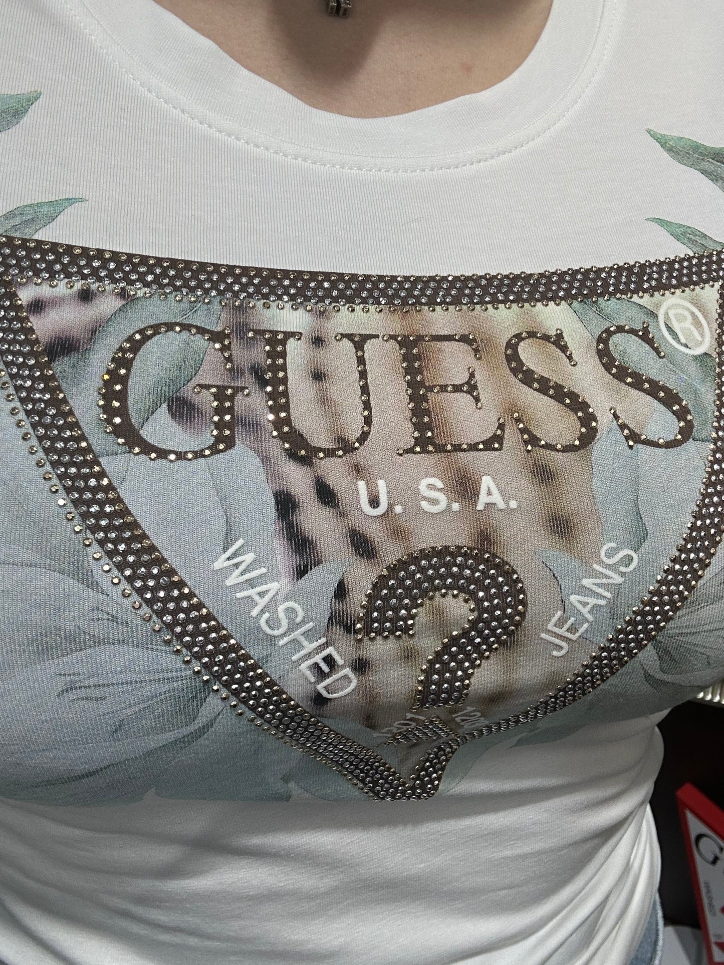 CAMISETA GUESS BLANCA CON LOGO FLORES Y TRIÁNGULO CHOCOLATE CON BRILLOS PLATEADOS Y DORADOS
